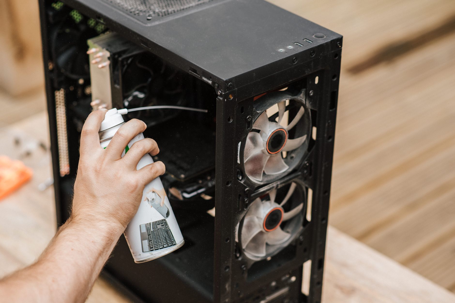 pessoa limpando o pó da ventoinha de um computador